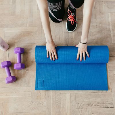 Dumbbells and a water bottle on a clean grey surface.